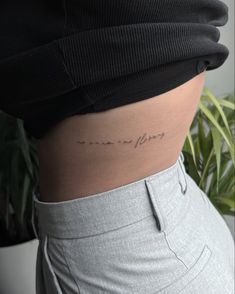 a woman's stomach with the word love tattooed on her lower side ribcage