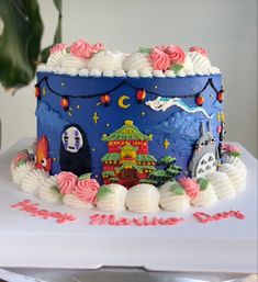 a blue cake with white frosting and colorful decorations