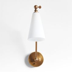 a wall light with a white shade on it's side and a gold finish