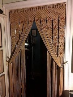 an open doorway with curtains and pictures on the wall