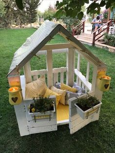 a little house made out of pallets and some plants