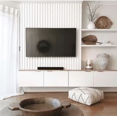 a flat screen tv sitting on top of a white entertainment center