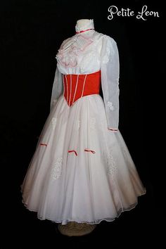 a white dress with red trims on the neckline and long sleeves is displayed in front of a black background