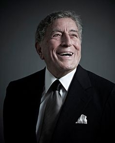 a man in a suit and tie smiling at the camera with his mouth open,