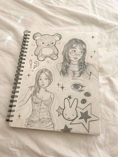 a notebook with drawings of two women and a teddy bear on the cover next to each other