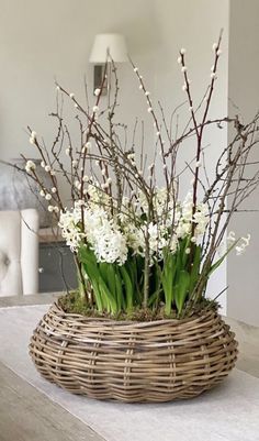 a wicker basket filled with flowers on top of a table