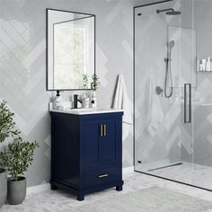 a bathroom with a blue cabinet, mirror and plant in the corner on the floor