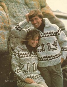 a man and woman in sweaters standing next to each other on the cover of a magazine