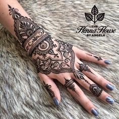 a woman's hand with henna tattoos on it