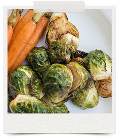 a white plate topped with brussel sprouts and carrots