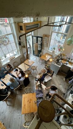 an overhead view of people sitting at tables in a room with lots of open windows