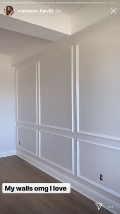 an empty room with white walls and wood flooring in the center, there is no image on the wall