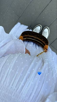 a white dress with blue hearts on it and a brown purse hanging from the back