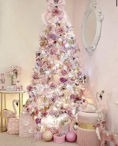 a white christmas tree with pink and gold decorations in a girls'room decorated for the holidays