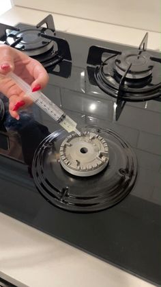 a woman is holding a thermometer in her hand while cooking on an electric stove