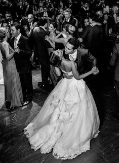 black and white photograph of bride and groom dancing in front of guests at wedding reception