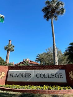 the sign for flagler college in front of palm trees