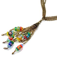 "This long, slinky necklace finishes with a chain tassel of millefiori glass beads and colorful glass donuts. The millefiori elements are handmade by bundling and firing filament rods which melds them into this tiny random flower pattern. No two beads are ever identical. From our Candy Glass Collection. Style N1492 Chain: 32\" Tassel: 4-1/2\" Made in our Los Angeles studios and signed Sweet Romance Jewelry, USA" Multicolor Long Tassel Necklace Gift, Multicolor Long Tassel Necklace For Gift, Bohemian Multicolor Murano Glass Beaded Necklace, Bohemian Multicolor Murano Glass Necklaces, Bohemian Multicolor Murano Glass Necklace, Bohemian Murano Glass Jewelry With Spacer Beads, Bohemian Murano Glass Spacer Beads Jewelry, Rustic Necklace, Locket Bracelet