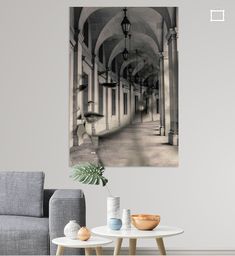 a black and white photo of a hallway in a building with columns on the wall