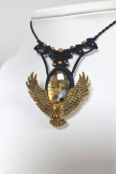 Discover this unique necklace that combines the elegance of yellow labradorite with a fantastical eagle design. The central stone, a luminous yellow labradorite, catches the light with iridescent sparkles, adding a mystical touch to the whole. The eagle, with its wings spread and finely detailed, seems ready to take flight, symbolizing strength and freedom. Hematite beads harmoniously complete this jewel, accentuating its natural and magical charm. This necklace is more than just an accessory; i Eagle Spread Wings Necklace, Eagle Bird, Fantasy Style, Eagle Design, For Her Gifts, Macrame Necklace, Hematite Beads, Unique Necklace, Unique Necklaces