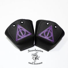 two black and purple wrist pads with harry potter symbols on them