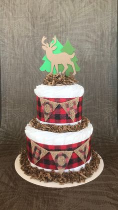 a three tiered cake decorated with plaid and deer decorations