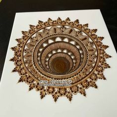 an intricately designed greeting card with gold foil on white paper, featuring a circular design