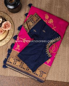 Gorgeous rani-pink Banarasi Munga Silk saree gilded with rose and shoot zari, finished with navy-blue border and pallu, also gilded with intricate zari, tassels at the pallu, paired with a navy-blue blouse, rich with a kundan zardosi-lined deep neck and intricate rose zari at the sleeves Blue And Pink Saree Blouse Designs, Pink And Blue Saree Blouses, Traditional Pink Pre-draped Saree With Embroidered Border, Festive Pink Blouse With Embroidered Border, Designer Pink Saree With Embroidered Border, Pink Pre-draped Saree With Embroidered Border For Diwali, Festive Pink Blouse Piece With Embroidered Border, Pink Dola Silk Blouse Piece With Embroidered Border, Pink Pre-draped Saree With Embroidered Border For Eid