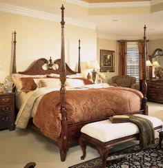 a large bed sitting in the middle of a bedroom next to a dresser and chair