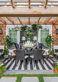 an outdoor dining area with black and white striped flooring, potted plants and greenery