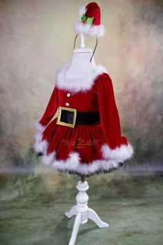 a red and white dress with santa claus's hat is on a mannequin