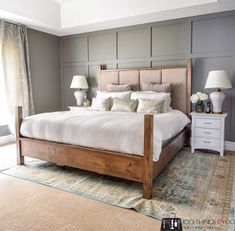 a bedroom with a bed, nightstands and two lamps on either side of the bed