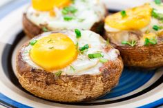 three baked potatoes topped with eggs on a blue and white plate