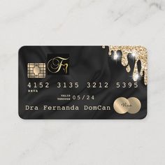 a black and gold credit card with diamonds on it, sitting on a marble surface