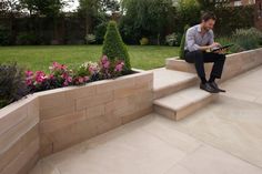 a man is sitting on the steps outside using his tablet computer and looking at it