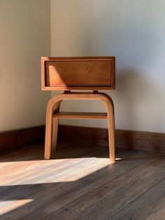 a wooden chair sitting on top of a hard wood floor next to a white wall