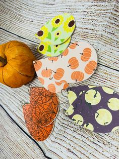 four pieces of paper with pumpkins and leaves on them sitting next to each other