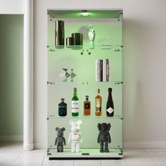 a glass shelf filled with bottles and figurines on top of it's sides