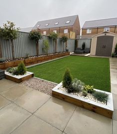 a backyard with grass and wooden planters in the middle, surrounded by fenced area