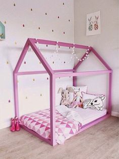 a child's bed with pink and white decor