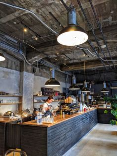 the interior of a restaurant with exposed ceilings and wooden counter tops, along with hanging lights