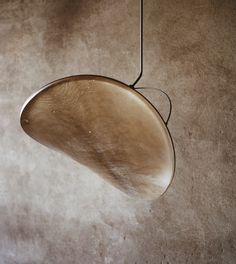 a light fixture hanging from the ceiling in a room with concrete walls and flooring