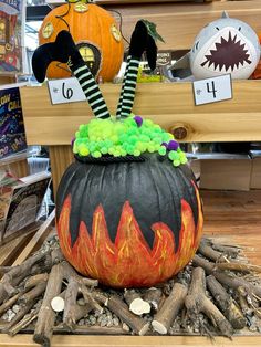 a decorated pumpkin sitting on top of a pile of wood