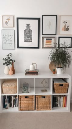 a white shelf with baskets and pictures on it