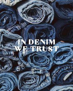 the words in denim we trust surrounded by rolled up blue jeans on top of each other