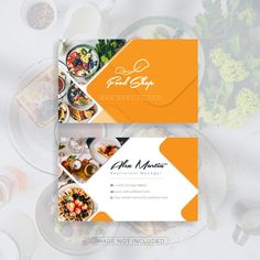 an orange and white business card on top of a table filled with plates of food