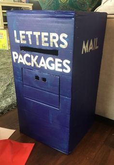 a blue mail box sitting on top of a wooden floor