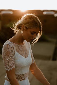 a woman in a white dress is standing outside