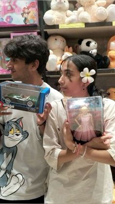 two people standing in front of shelves with stuffed animals