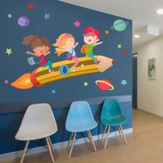 children's room with wall decals and chairs in front of the space theme